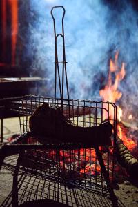 a grill with a fire in the background at Parsons River Camp in Balule Game Reserve