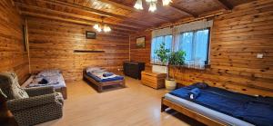 a room with two beds and a tv in a log cabin at Chata Górska Sowa, Cały Dom tylko dla Was in Podgórzyn