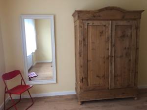 a room with a wooden cabinet and a mirror at Blick ins Grüne in Idar-Oberstein