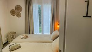 a bedroom with two beds in front of a window at Rivéa Bizy - Villa 150m2 - 2ou5 CH - 2 SDB - Parking Wifi in Vernon