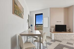 a dining room with a table and chairs and a television at Case Vacanze Celeste in Marzamemi