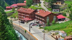 a town with buildings on a hill next to a river at Goblec Otel in Uzungöl