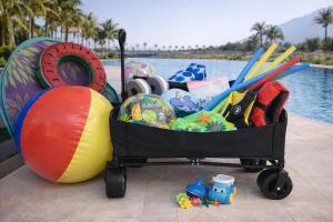a cart full of toys next to a pool at Family Floatie Flat with Pool & Workspace in As Sīfah