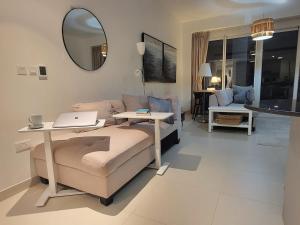 a living room with a couch and a table and a mirror at Family Floatie Flat with Pool & Workspace in As Sīfah