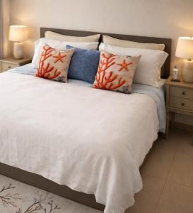 a bedroom with a white bed with pillows at Family Floatie Flat with Pool & Workspace in As Sīfah +23 photos