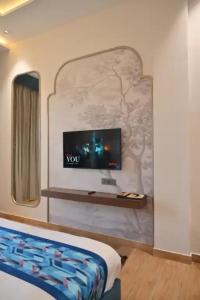 a bedroom with a tv on a wall at Hotel Phantom in Gangānagar