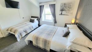 a bedroom with two beds and a window at The Queens Hotel Harlech in Harlech