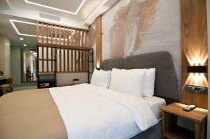 a bedroom with a large white bed and a table at Forty Nişantaşı Hotel & SPA in Istanbul