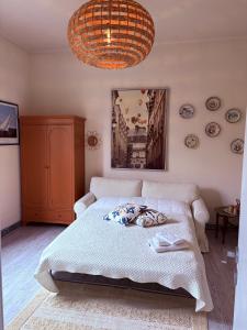 a bedroom with a bed and a chandelier at La Casetta di Dante in Marina di Carrara +17 photos