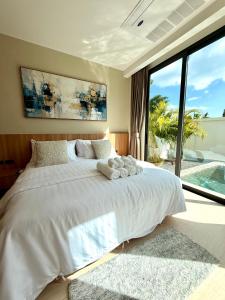 a bedroom with a white bed and a large window at Chareen Pool Villa in Ban Khlong Haeng +64 photos