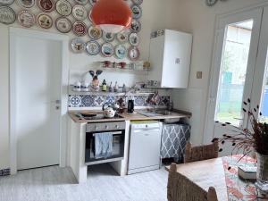 a kitchen with white appliances and plates on the wall at La Casetta di Dante in Marina di Carrara