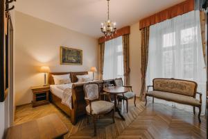 a bedroom with a bed and a table and chairs at Pałac Brunów - Wellness & SPA in Lwówek Śląski