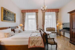 a bedroom with a bed and a table and chairs at Pałac Brunów - Wellness & SPA in Lwówek Śląski