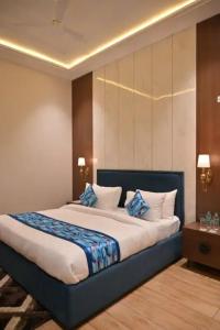 a bedroom with a large bed with blue and white pillows at Hotel Phantom in Gangānagar