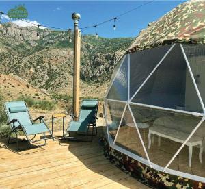 a dome tent with chairs and a table on a deck at Eco Dom Tent in Vedi
