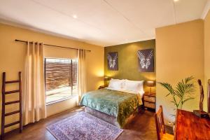 a bedroom with a bed and a window at Parsons River Camp in Balule Game Reserve +80 photos