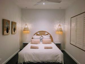 a bedroom with a bed with white sheets and pillows at Stunning Bush Beach House! NEW! in Elizabeth Beach
