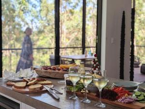 a table with glasses of wine and food on it at Stunning Bush Beach House! NEW! in Elizabeth Beach