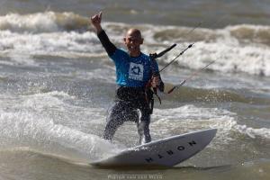 a man riding a wave on a surfboard in the ocean at Skip Inn Strandhuisjes in Katwijk aan Zee