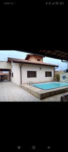 a building with a swimming pool in front of it at Casa de praia in Peruíbe