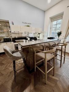 a kitchen with a counter with chairs and a table at Le Chouette Loft in Dijon