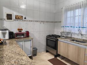 a kitchen with a sink and a stove top oven at Casa de praia in Peruíbe
