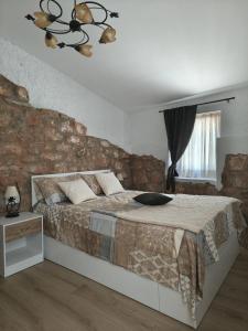 a bedroom with a large bed with a stone wall at Mas Lloretó - El Rossinyol in Copóns