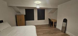 a bedroom with a bed and a desk and a table at Spacious Two Bedroom Flat with Dedicated Workspace in Worsley in Worsley