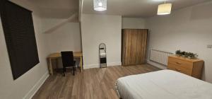 a bedroom with a bed and a desk and a table at Spacious Two Bedroom Flat with Dedicated Workspace in Worsley in Worsley