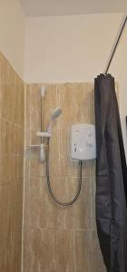 a shower with a sink and an umbrella in a bathroom at Spacious Two Bedroom Flat with Dedicated Workspace in Worsley in Worsley +3 photos