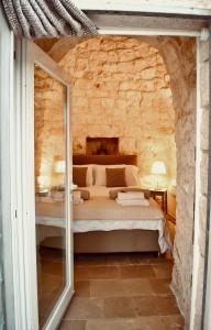 a bedroom with a bed in a stone wall at Trullo Theodoro Puglia in Ceglie Messapica +77 photos