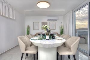 a white dining room with a white table and chairs at Mountain Top Views -205- נופי פסגות in Safed