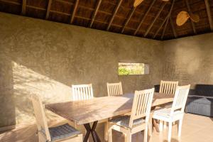 a dining room with a wooden table and chairs at Adouna Bay in Cap Skirring