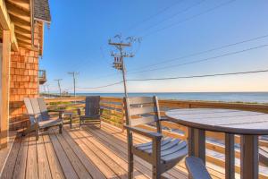 a deck with a table and chairs and the ocean at 4115 - Coastal Cottage in Kitty Hawk