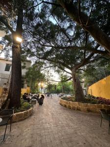 a courtyard with trees and people sitting on benches at Mar Mkhayel Studios in Beirut