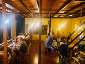 a group of people sitting at tables in a restaurant at The Rainforest Hideaway in Deniyaya
