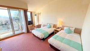 a hotel room with two beds and a window at Livemax Resort Yatsugatake Kogen in Hokuto +19 photos