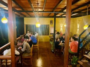 a group of people sitting at tables in a restaurant at The Rainforest Hideaway in Deniyaya
