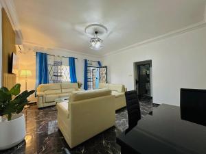 a living room with couches and a table at CAMERHOME Banque SCB Cité des palmiers in Douala
