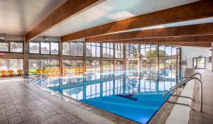 a large swimming pool in a building with windows at Lavi Kibbutz Hotel in Lavi