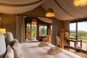a bedroom with a bed with two towels on it at The Maa Guest House in Talek