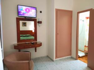 a room with a mirror and a chair and a television at Hotel Splendid in Fez