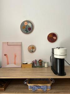 a counter with a coffee maker and plates on a wall at Florija’s Guesthouse in Dardhë