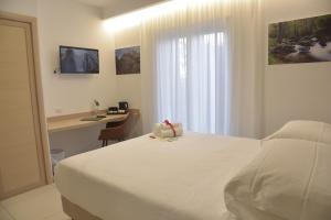 a hotel room with a bed and a desk and a bed sidx sidx sidx sidx at Hotel Floris in Rende