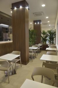 a restaurant with tables and chairs and plants at Hotel Floris in Rende