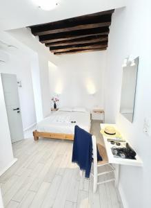 a white bedroom with a bed and a table at Castellino Naxos in Naxos Chora