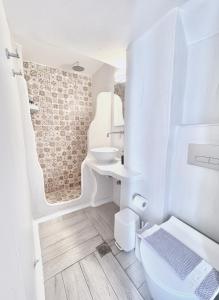 a white bathroom with a sink and a toilet at Castellino Naxos in Naxos Chora +30 photos