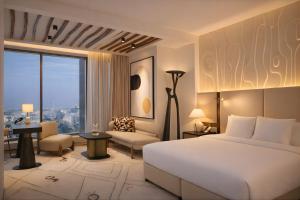 a hotel room with a bed and a large window at The H Dubai in Dubai