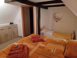 a bedroom with a large bed with towels on it at "Ferienhaus-Ottendorf" mit Pool und Infarotkabine in Ottendorf +17 photos