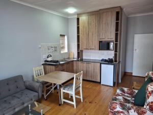 a kitchen and living room with a table and a couch at R & A's Cottage in Strand